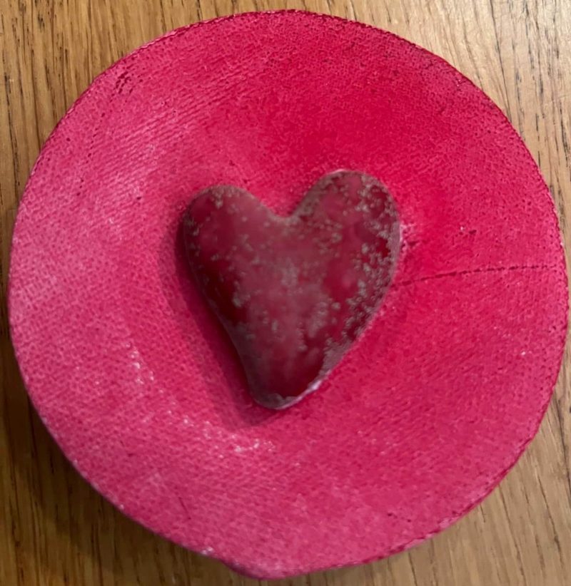 Rotes Herz aus Zement in einer runden Form